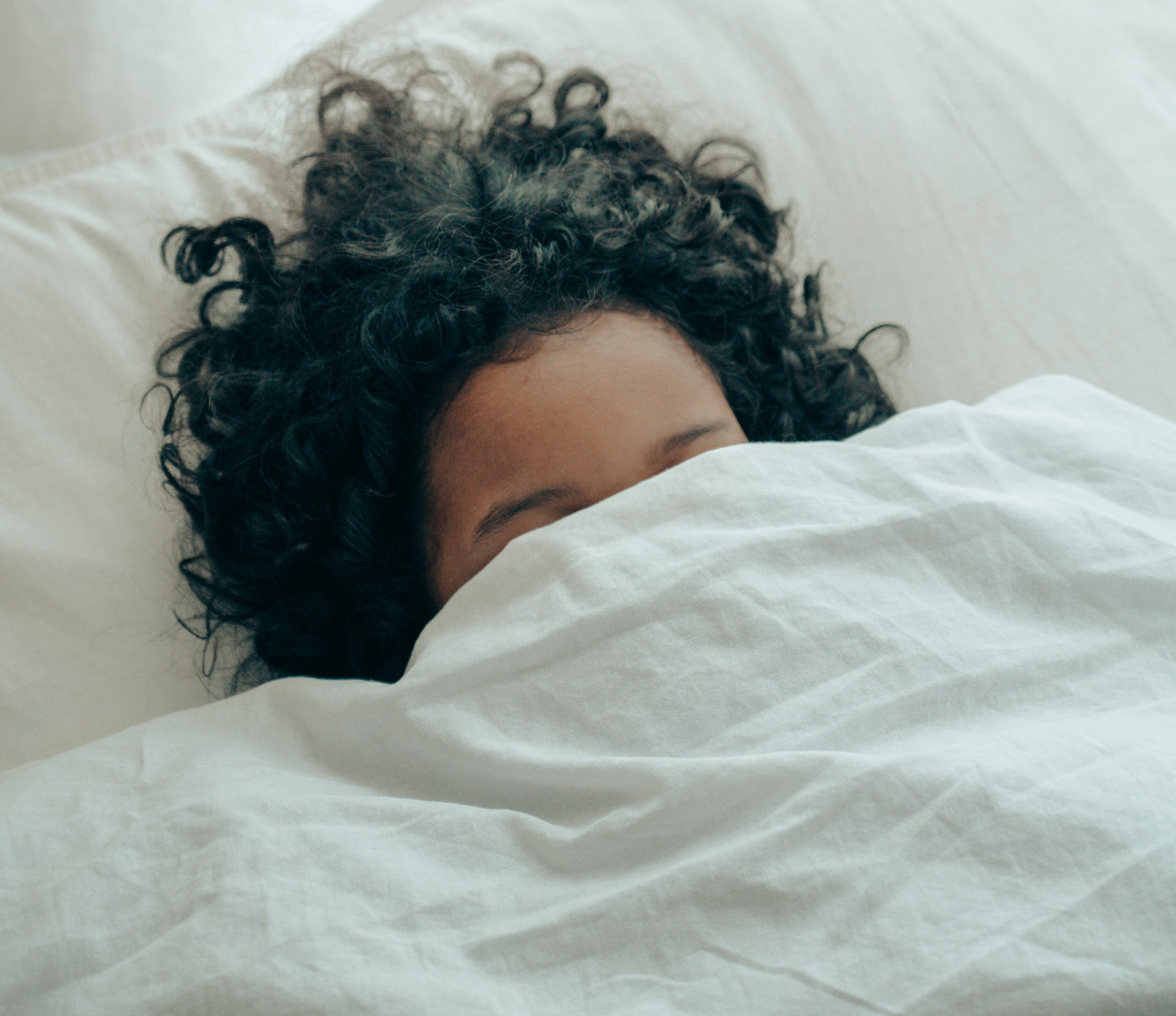 Image of woman under the sheet with head sticking out