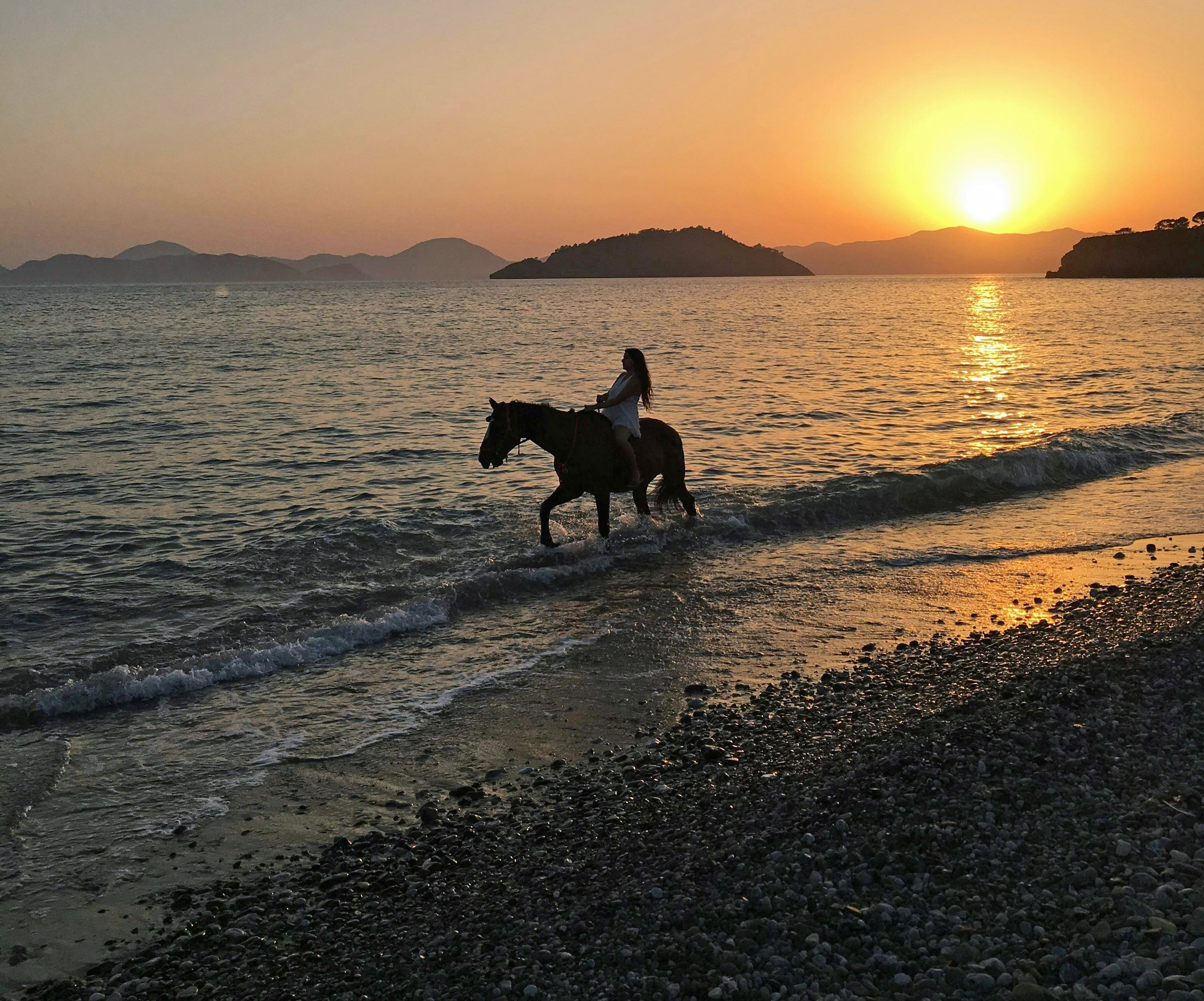 Woman on a horse at the shoreline